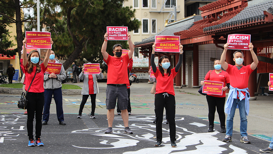 Nurses hold signs "Racism is a Public Health Crisis"