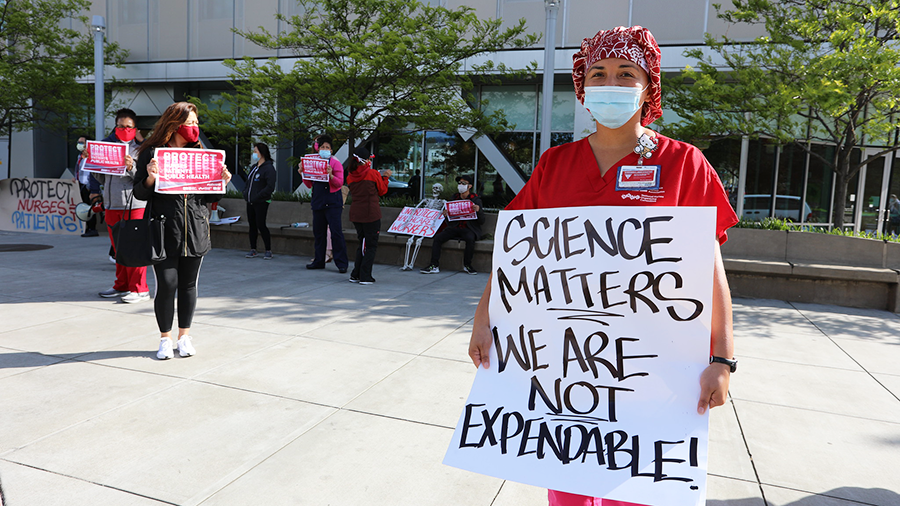 Nurse holding sign "Science matters, we are not expendable!"