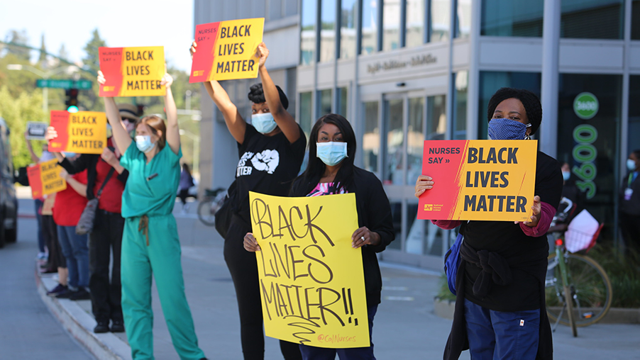 Nurse hold signs "Black Lives Matter"