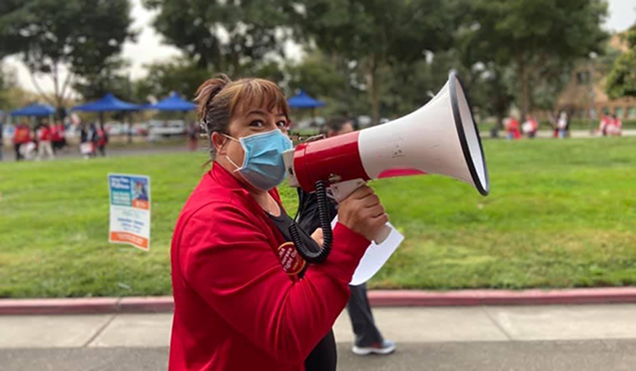 Masked nurse speaking into megaphone