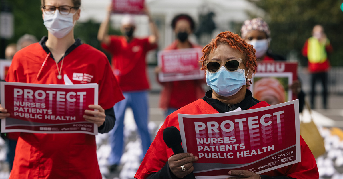Masked nurse outside holds signs "Protect Nurses, Patients, Public Health"