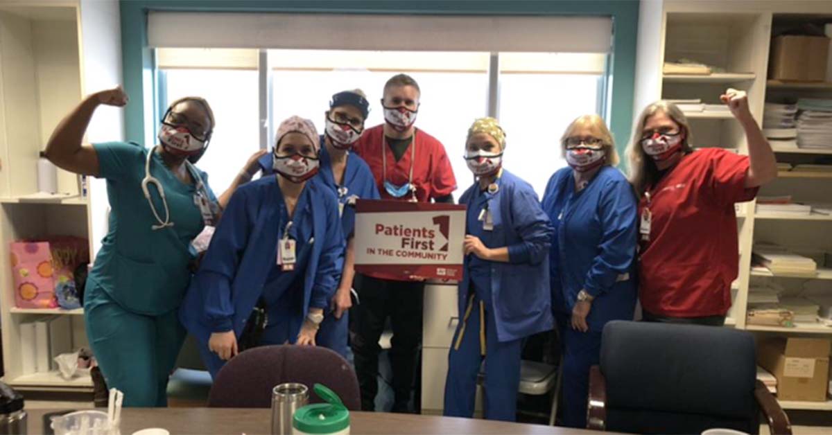 Group of nurses inside hospital with raised fists