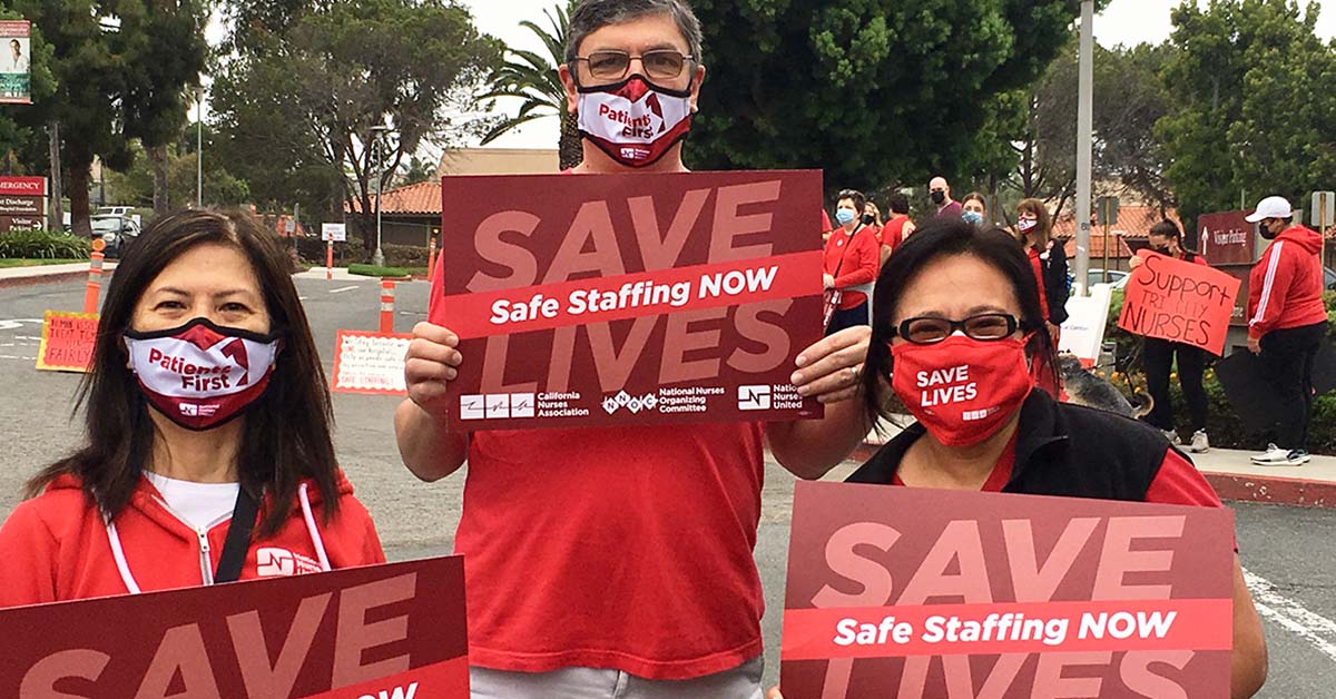 3 nurses outside hold signs "Safe Staffing Now"