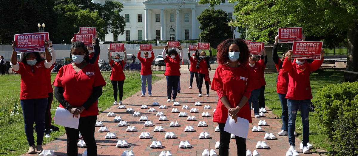 Large group of nurses outside the White House holds sign "Protect Nurses, Patients, Public Health"