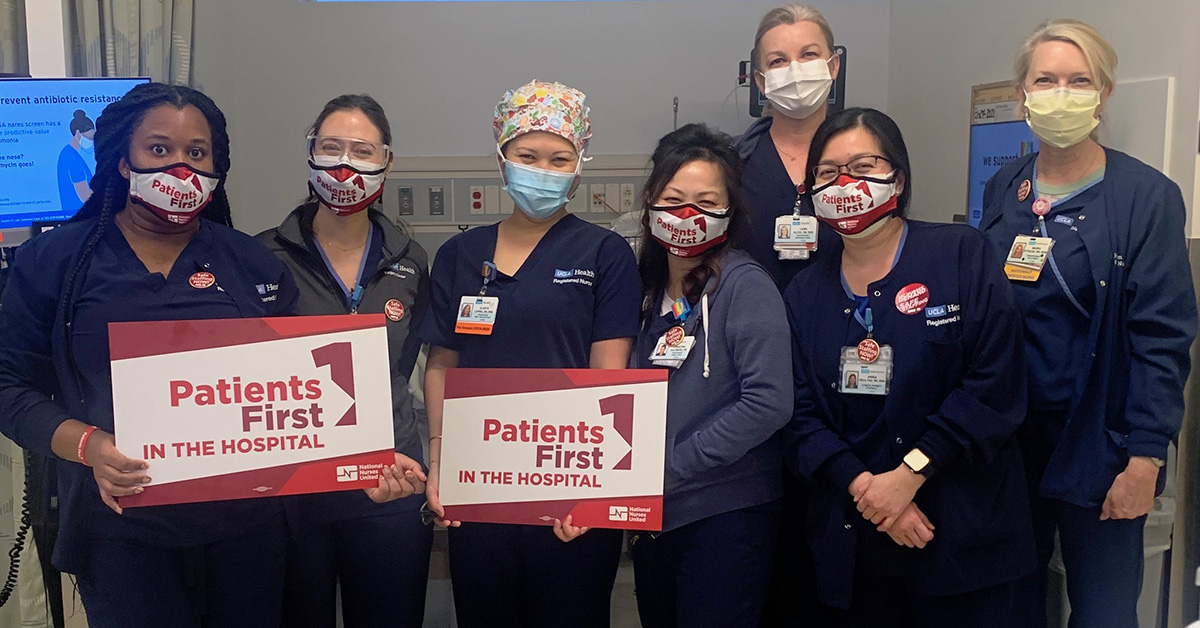 Group of nurses inside hospital hold signs "Patients First in the Hospital"