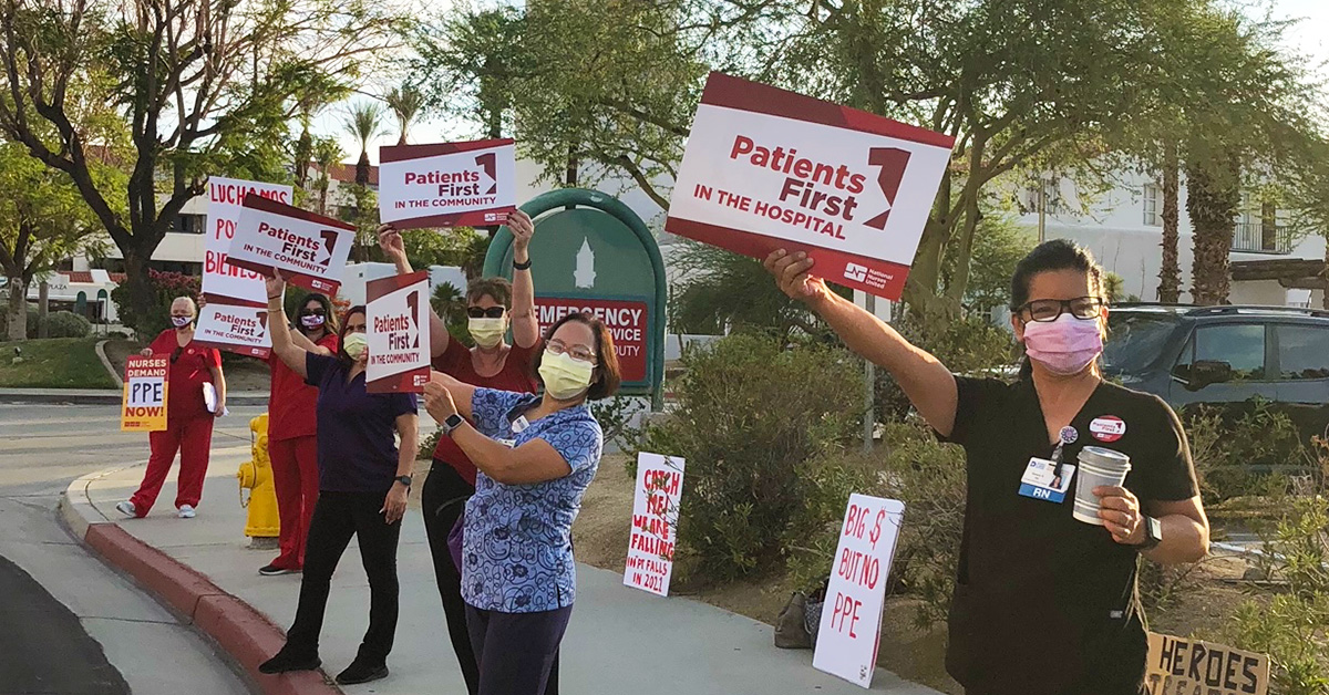 Nurses outside hospital hold signs "Patients First"