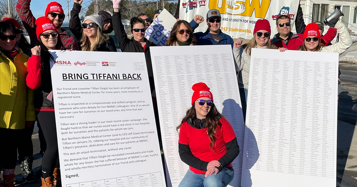 Group of nurses outside holding huge petition with signatures