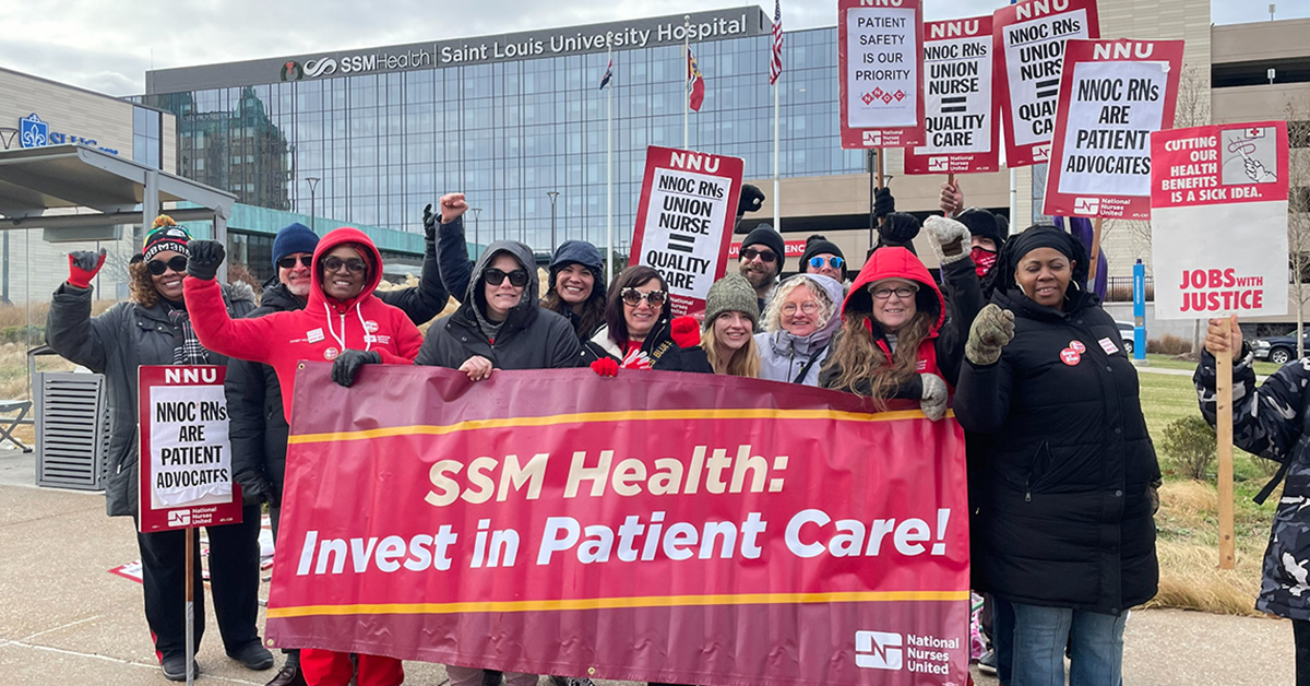 Group of nurses outside Saint Louis University Hospital holding banner "SSM Health: Invest in Patient Care!"