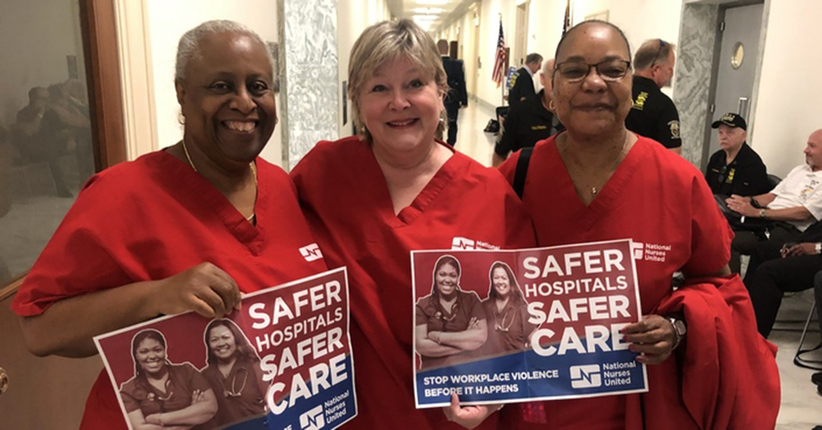 Nurses in DC government hallway with signs "Safer hospitals safer care. Stop workplace violence before it happens"