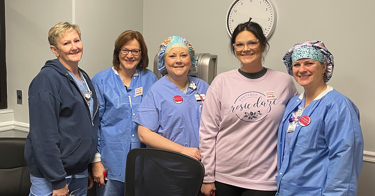 5 nurses inside hospital smiling