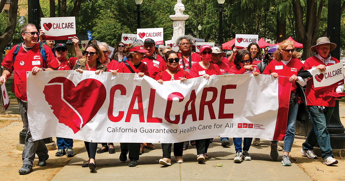 Group of nurses in scrubs marching holding "CalCare"