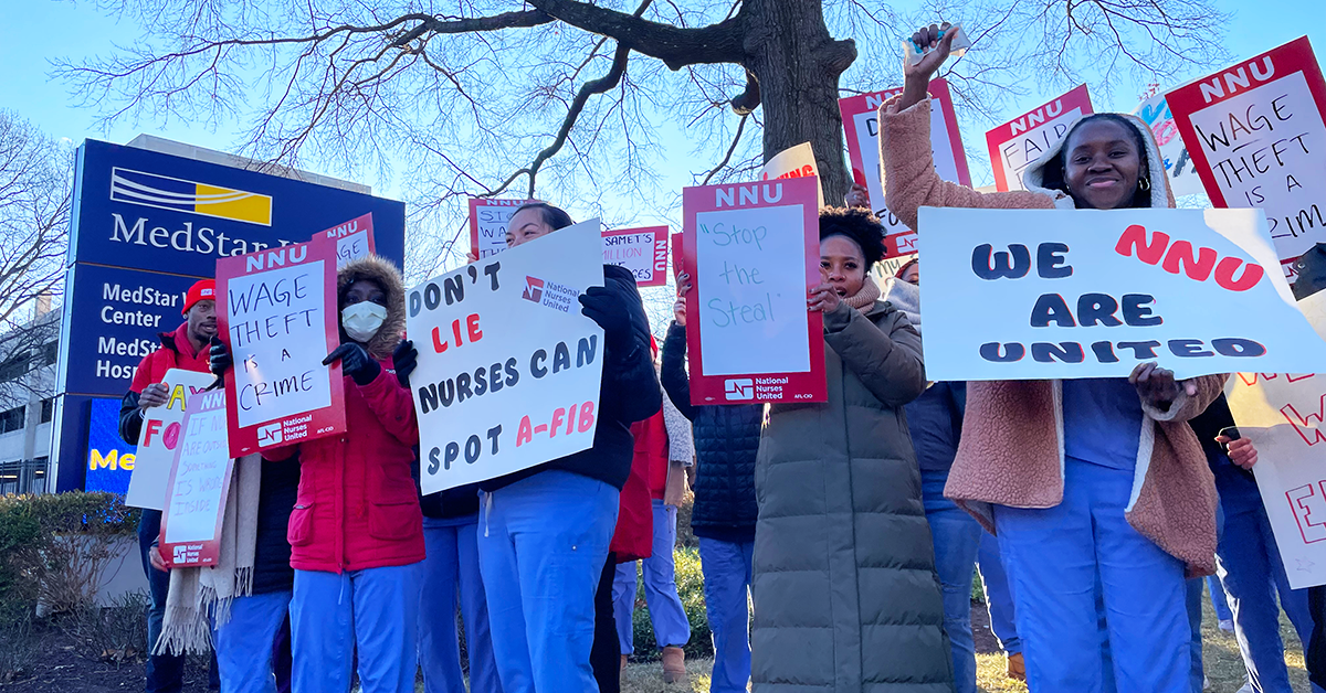 MedStar nurses in front of hospital with signs: "Wage theft is a crime" "Don't lie, nurses can spot a-fib" "Stop the steal" "We are NNU united"