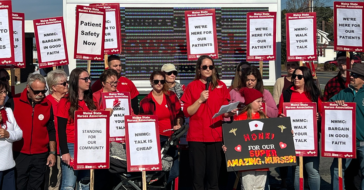 Nurses rally outside of hospital holding signs "We're here for our patients"