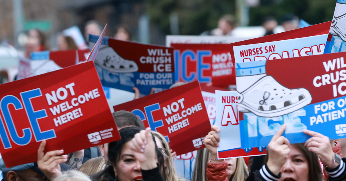Hands holding signs "ICE not welcome here" and "Abolish ICE"