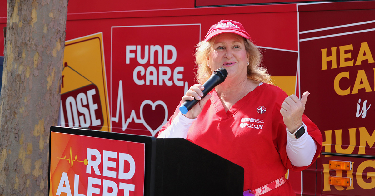 Sandy Reding, RN, at podium in front of bus