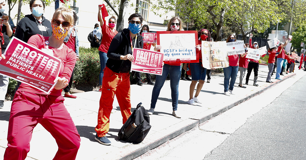 Nurses holding signs along street "Protect Nurses, Patients, Public Health"