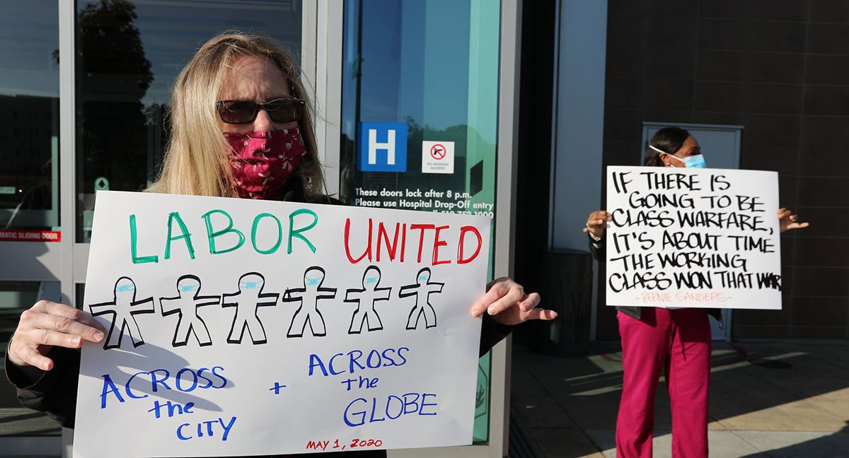 Nurse holds sign "Labor United"