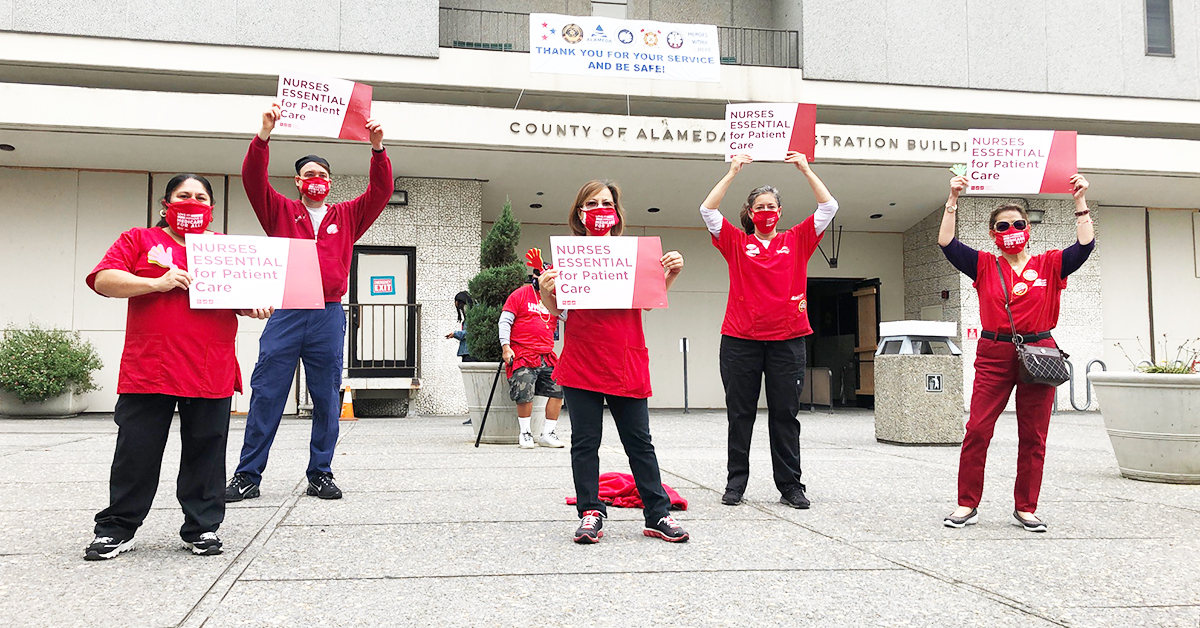 5 nurses in front of Alameda facility holding signs: NURSES ESSENTIAL for Patient Care