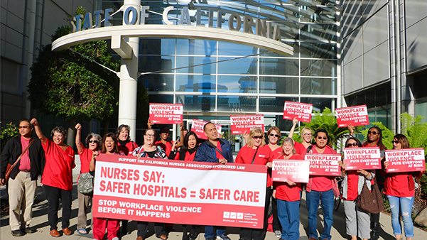 Nurses hold signs calling for Workplace Violence Prevention