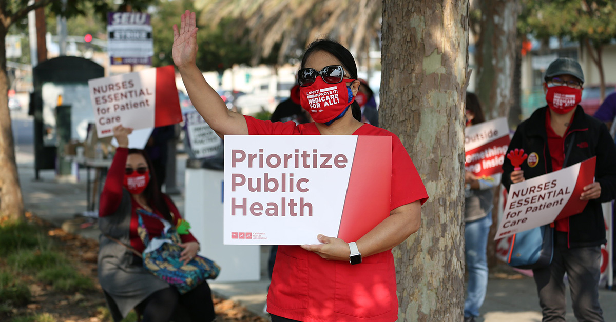Nurse hold signs "Prioritize public health"
