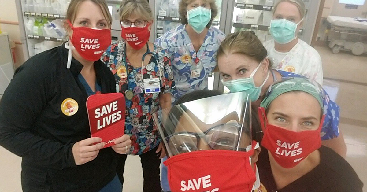 TCMC nurses holding signs and wearing masks "Save Lives"