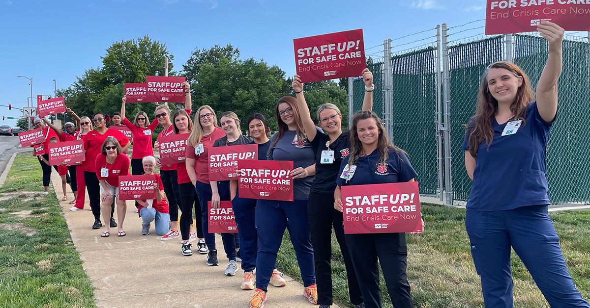 Long line of nurses holdings signs "Staff Up for Safe Patient Care"
