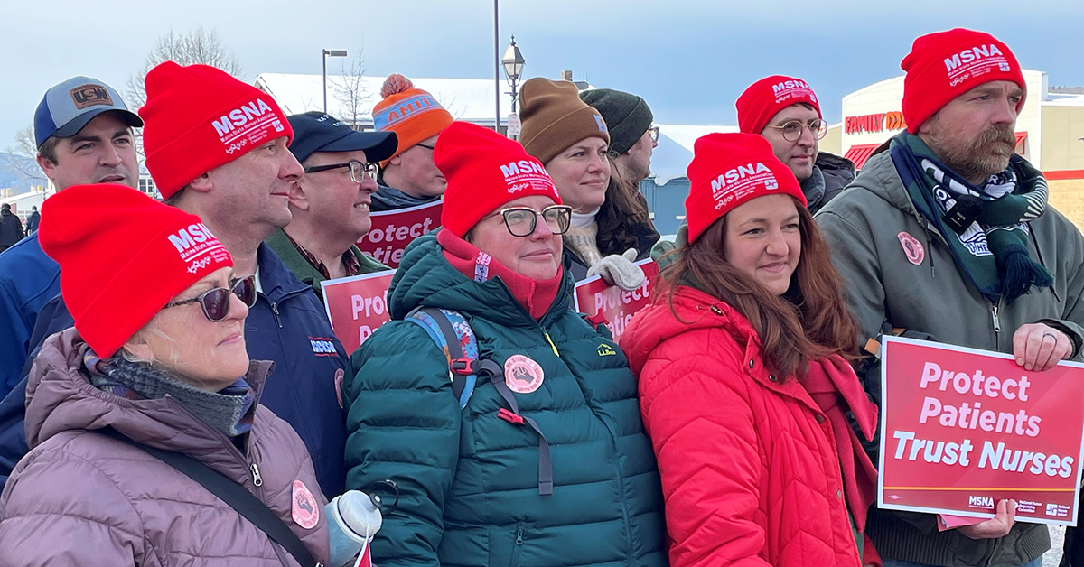 Group of nurses outside, in cold weather clothibg, wearing MSNA beanies, holding signs "Protect Patients, Trust Nurses"