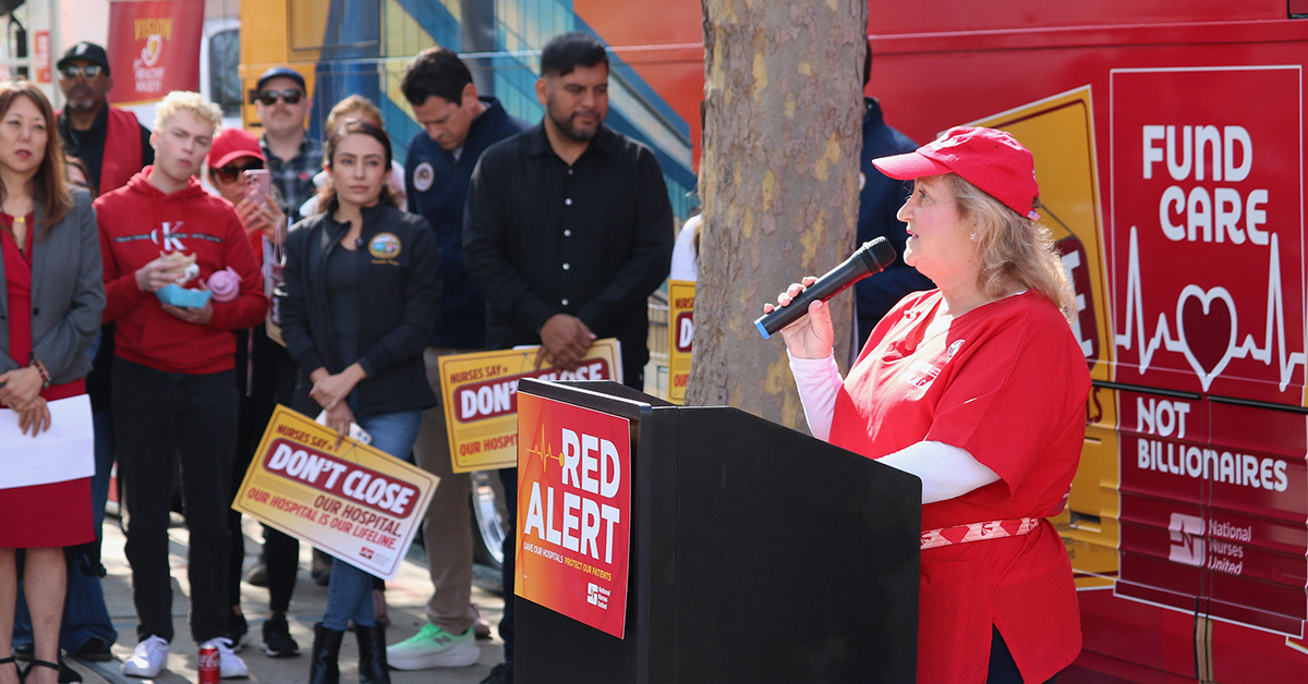 Nurse speaking at podium in front of Red Alert tour bus