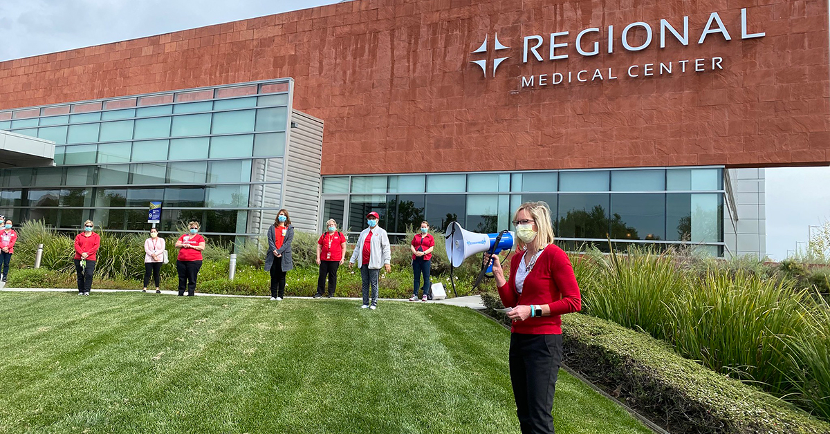 Speaker and nurses in front of Regional Medical Center building
