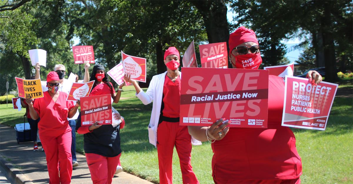 Nurses holds signs "Racial Justic Now"