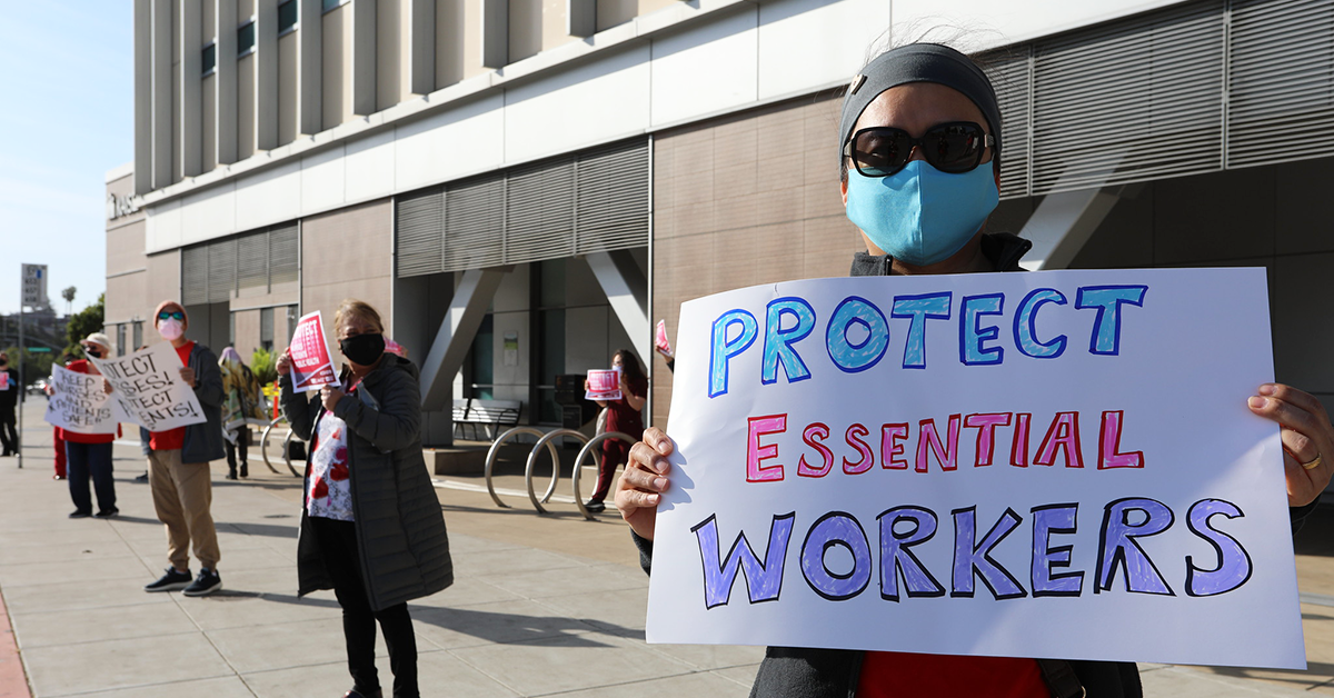 Nurse holds sign "Protect Essential Workers"