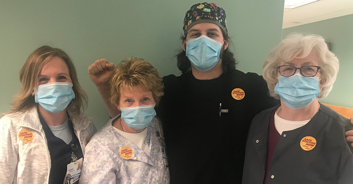 Group of four nurses inside hospital wearing stickers in support of safe staffing