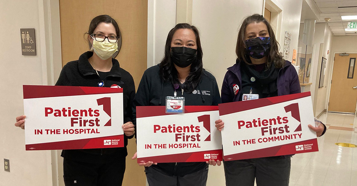 Three nurses inside hospital hold signs "Patients First"