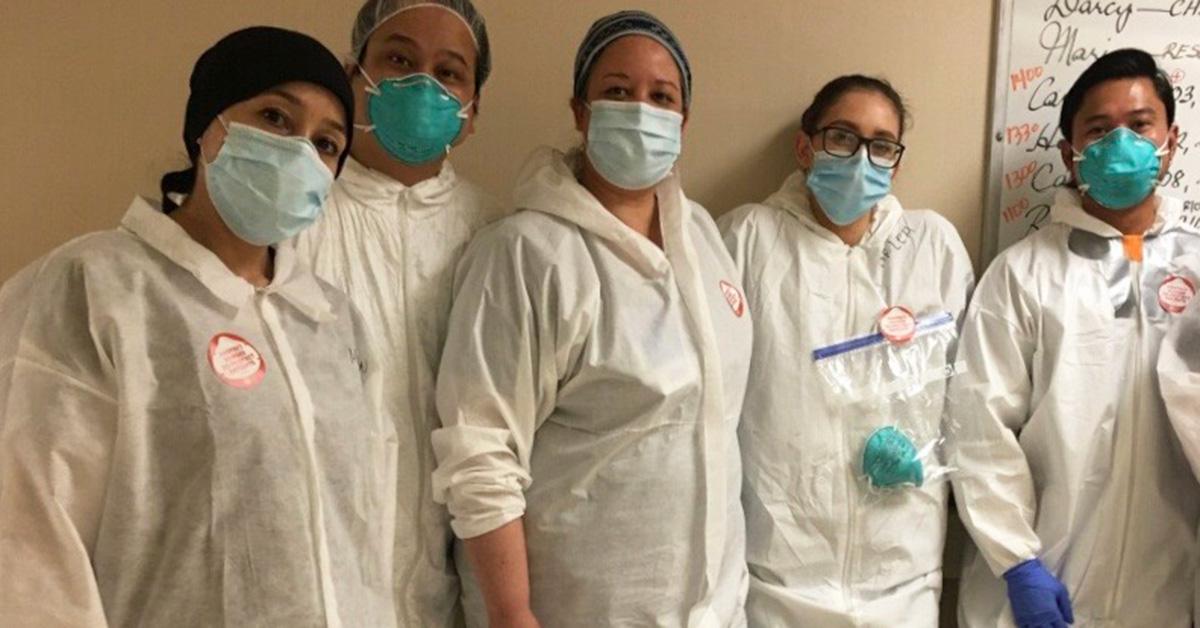 Group of five masked nurses inside hospital