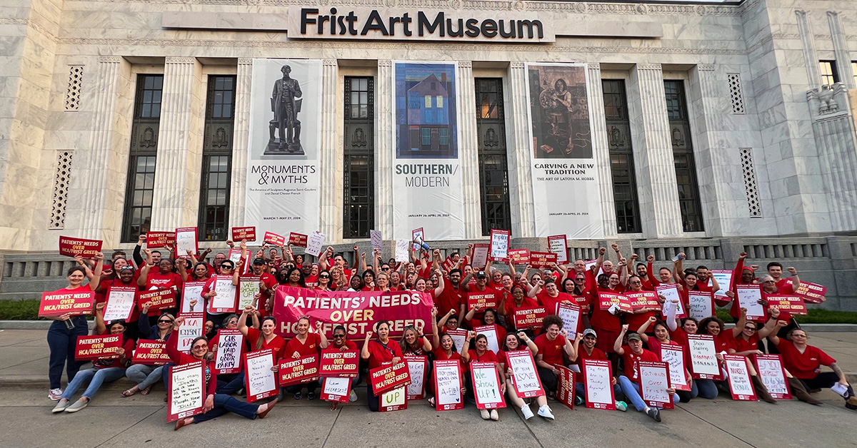 Large group of nurses outside Frist Art Museum holding banner "Patients Needs over HCA/Frist Greed"