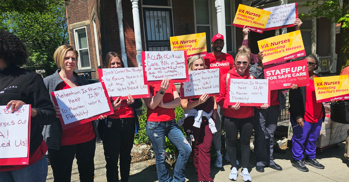 Group of VA nurses smiling, lots of diferent signs including "VA Nurses: Protecting America's Heroes"