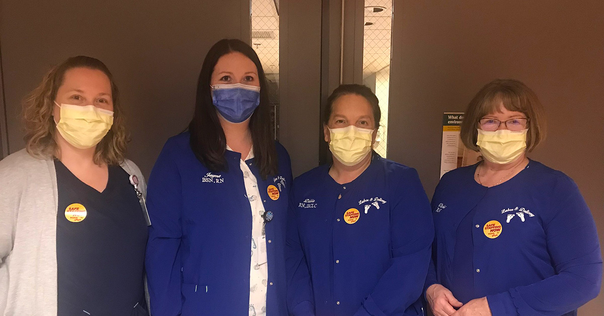 Four nurses inside hospital standing side-by-side