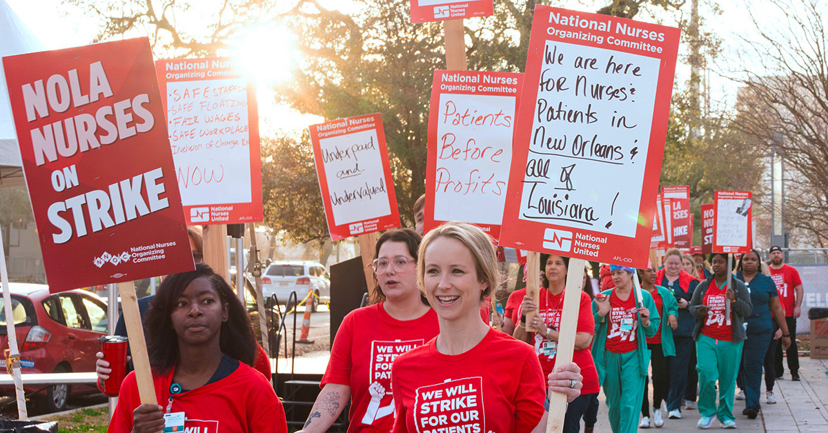 Nurses on picket line holding signs supporting patient safety and need
