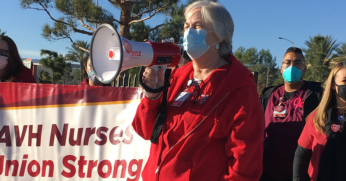 AVH RN speaks using megaphone in front of sign "AVH Nurses - Union Strong"