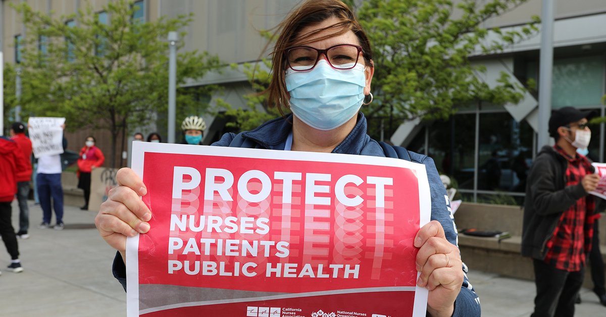 Nurse holds sign "Protect Nurses, Patients, Public Health"