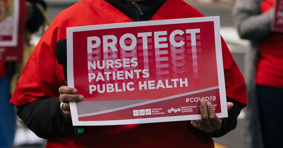 Nurse holds sign "Protect Nurses, Patients, Public Health"