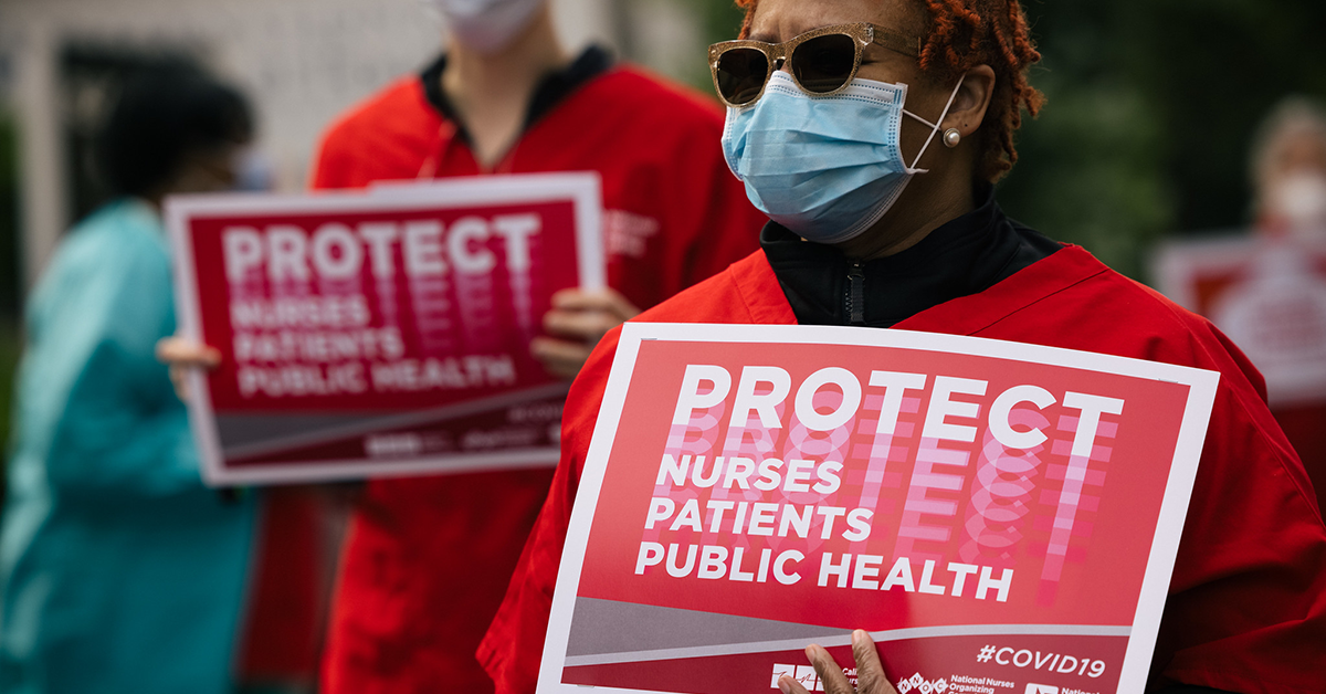 Nurse holds sign "Protect Nurses, Patients, Public Health"