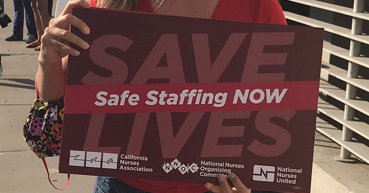 Nurse holds signs "Safe Staffing Now"