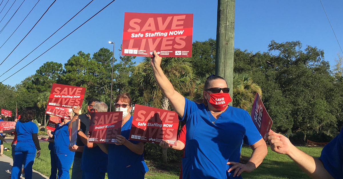 Nurses hold signs "Safe Staffing Now"