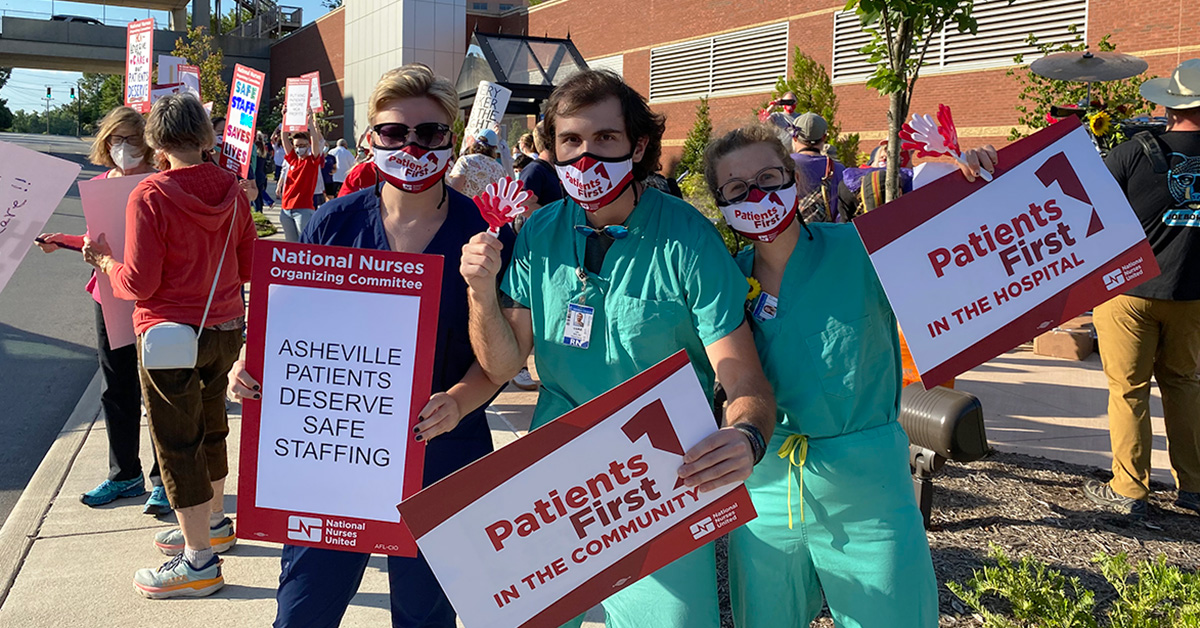 Group of three nurses outside Mission Hospital hold sign "Patients First"