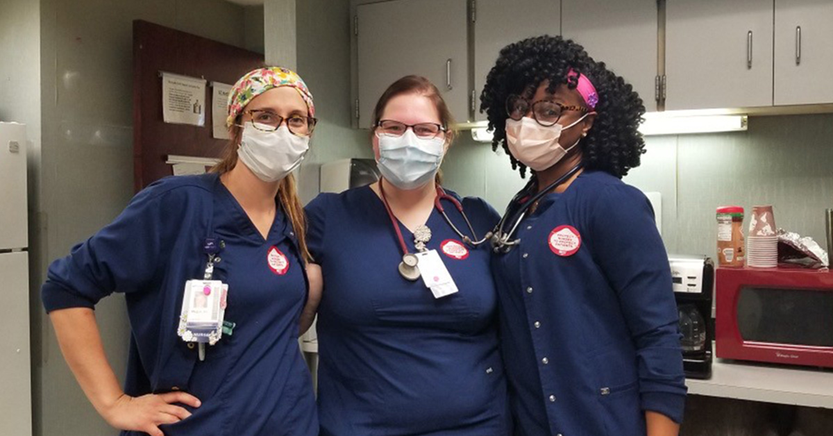 Three masked nurses inside hospital