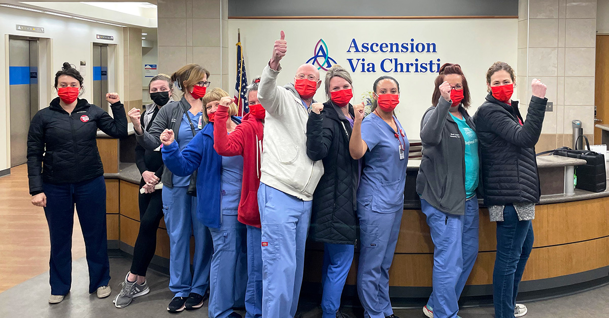 Group of nurses inside hospital giving thumbs up