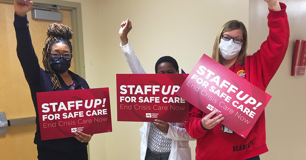 Three nurses with raised fists hold signs "Staff Up for Safe Care"