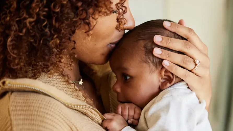 Mother holding baby on her shoulder