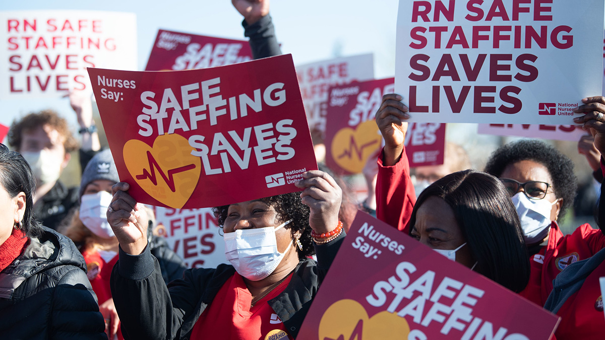 Nurses holding signs "Safe Staffing Saves Lives"